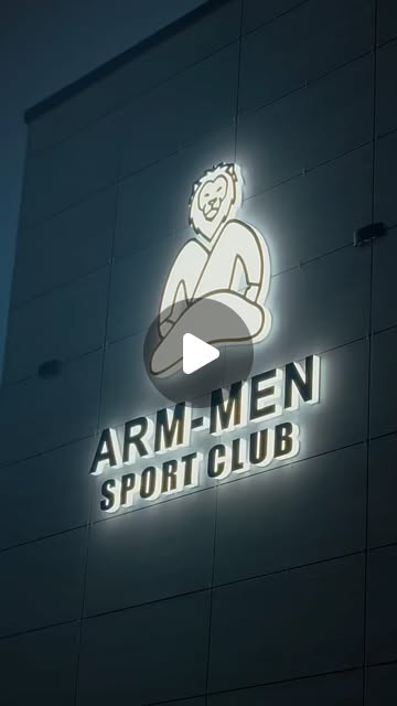 The ARM-MEN Sport Club sign lit up on the building